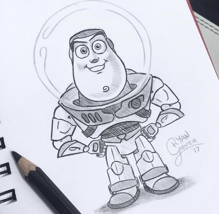 Sketch of a smiling astronaut in a spacesuit, with a pencil beside the drawing on a notebook page.