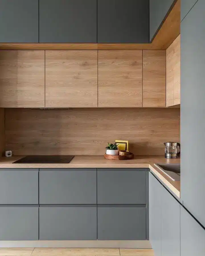 Modern kitchen with sleek gray cabinets and wooden accents, featuring a minimalistic design.