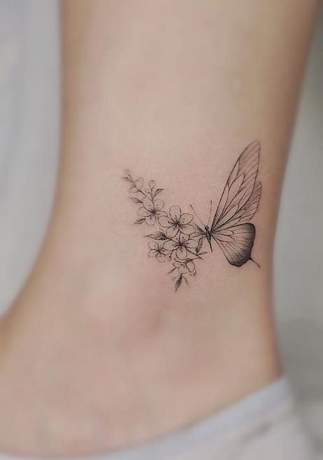 Minimalistic butterfly and flower tattoo on ankle, combining delicate designs for elegant body art.