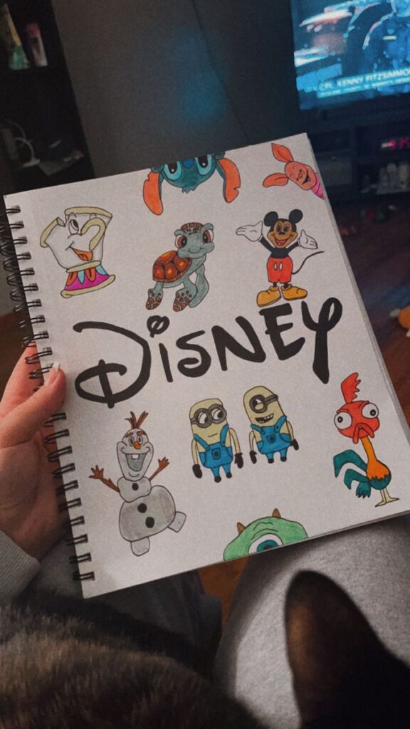 Spiral notebook with colorful drawings of popular animated characters and the word Disney artistically written.