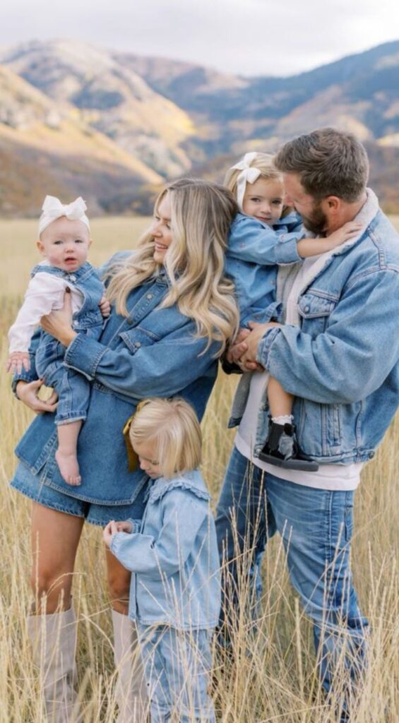 Family in denim outfits enjoying nature in a scenic mountain field.