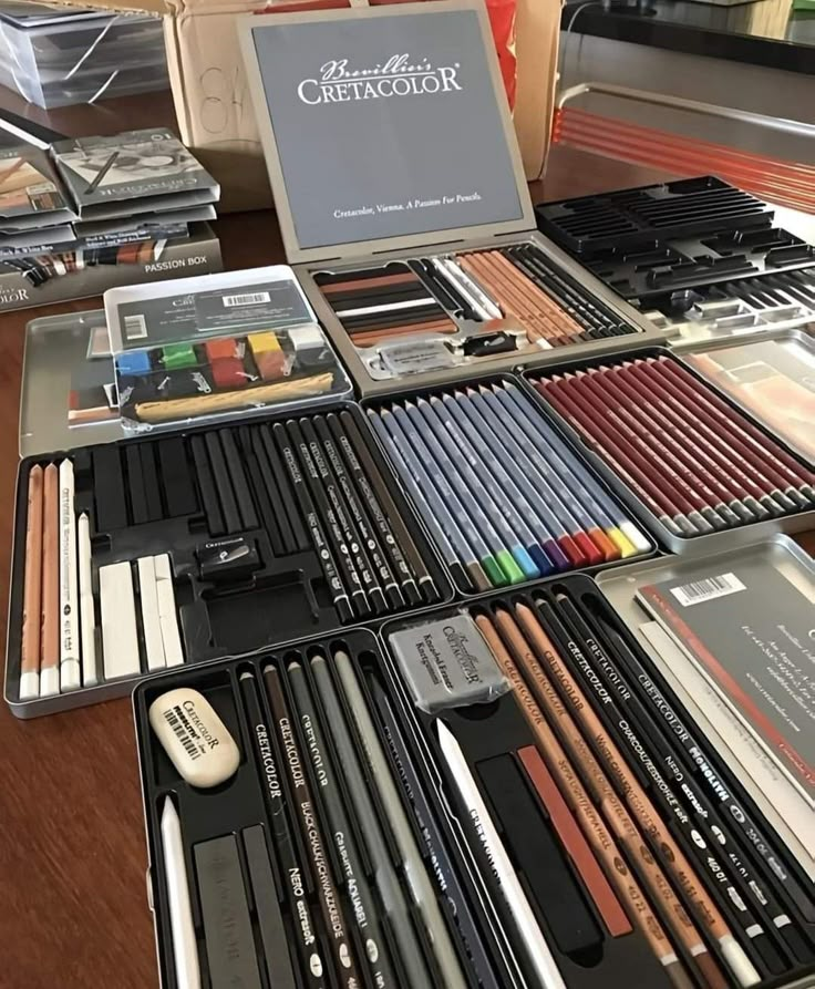 Cretacolor art supplies set: assorted pencils, pastels, and charcoals in an organized display on a table.