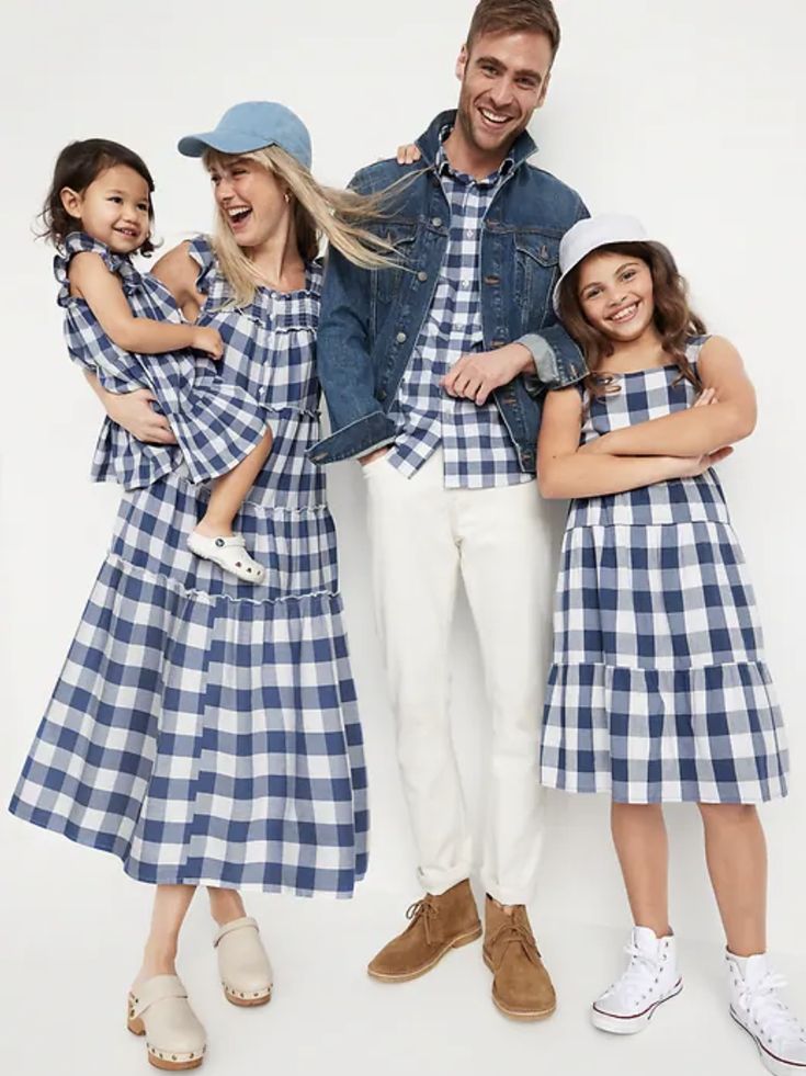 Family in matching blue checkered outfits and hats, smiling and posing together for a casual family photo.