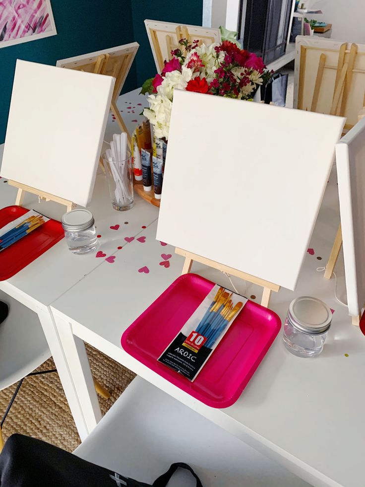 Painting setup with blank canvases, paintbrushes, and flowers, ideal for art classes or creative events.