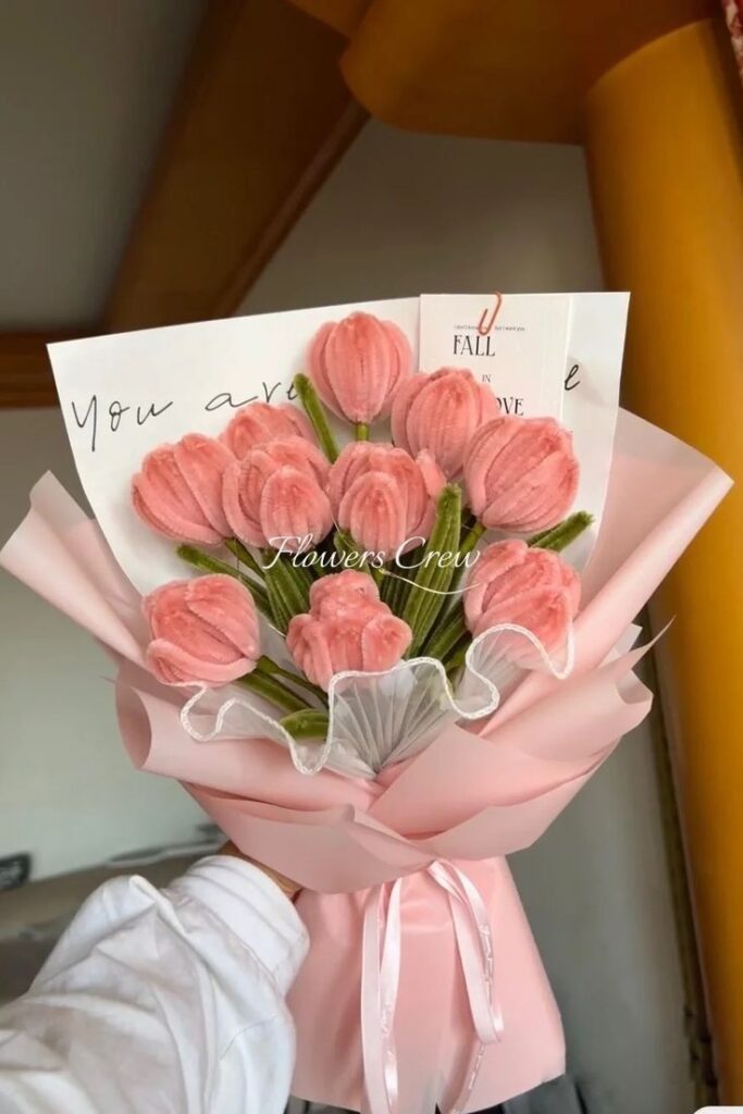 Bouquet of pink tulips wrapped in pastel paper with a love note, perfect for a romantic gift or decoration.