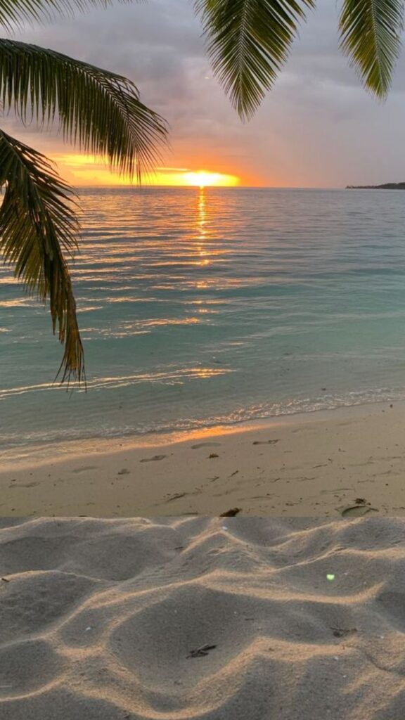 Tropical beach sunrise with palm leaves and ocean waves reflecting the golden sunlight, serene and peaceful scene.