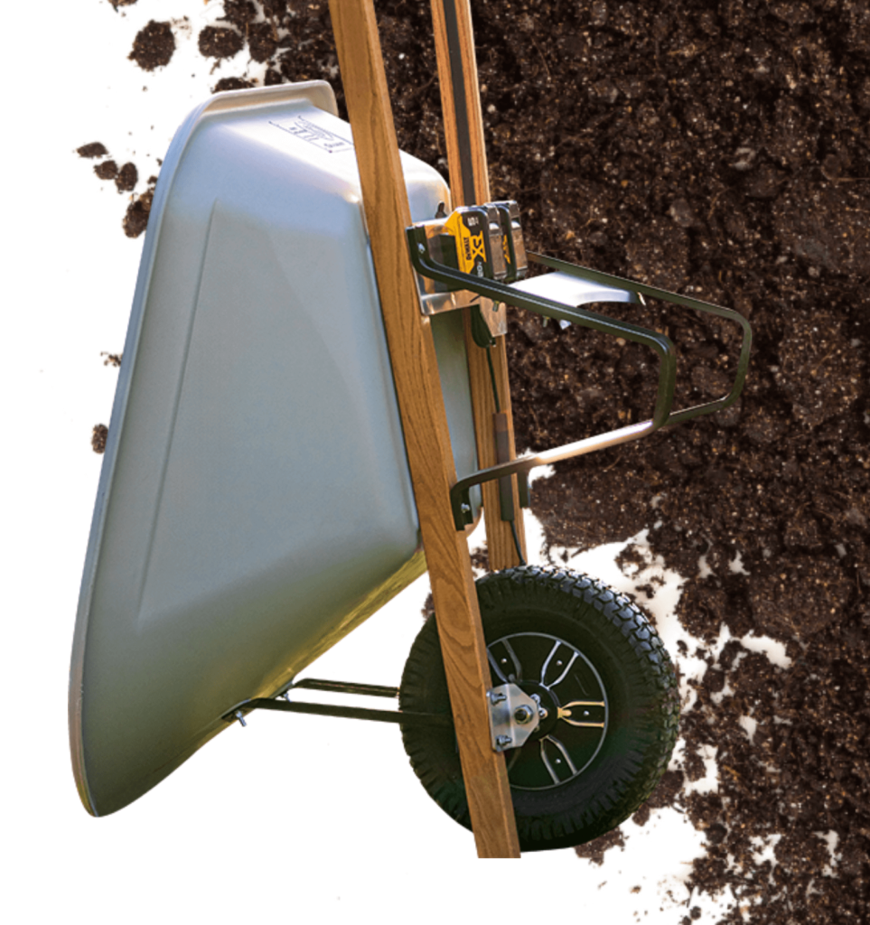 Wheelbarrow tilted on soil background, showcasing sturdy design and durable wheel for gardening tasks.