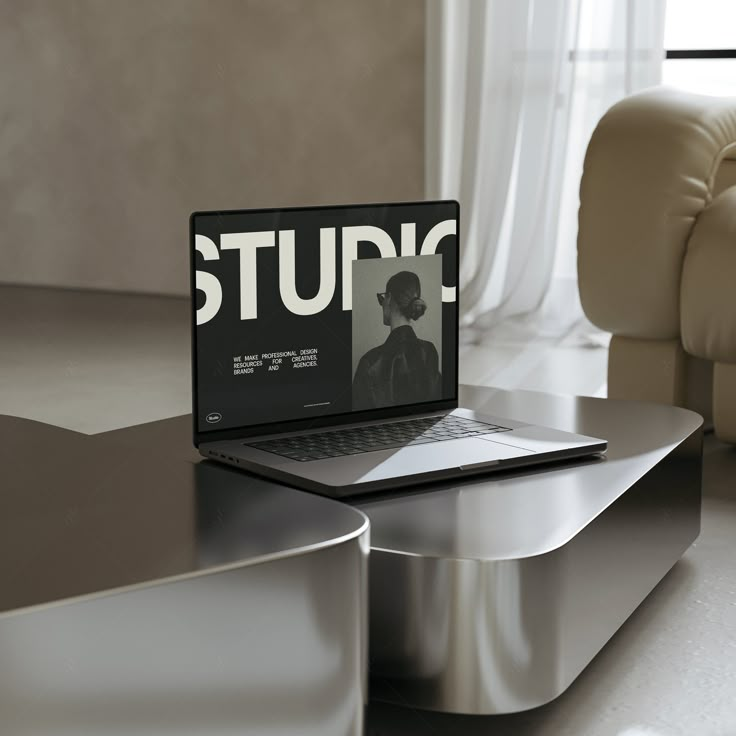 Sleek laptop on modern table displaying a design studio interface, natural light, and stylish interior background.