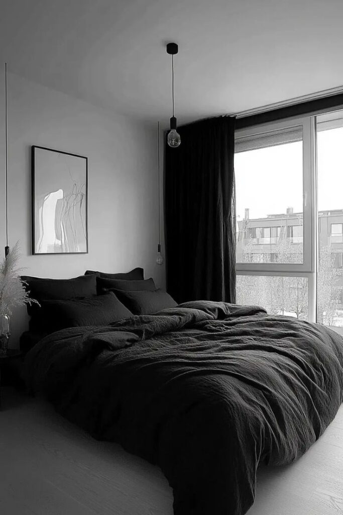 Stylish bedroom with dark bedding and large window, modern decor, minimalistic art on wall.