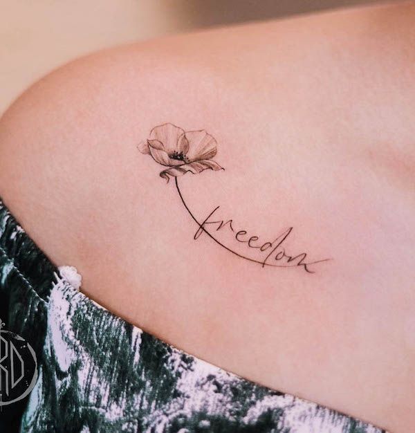 Minimalist flower tattoo with freedom text on a shoulder, symbolizing beauty and independence.