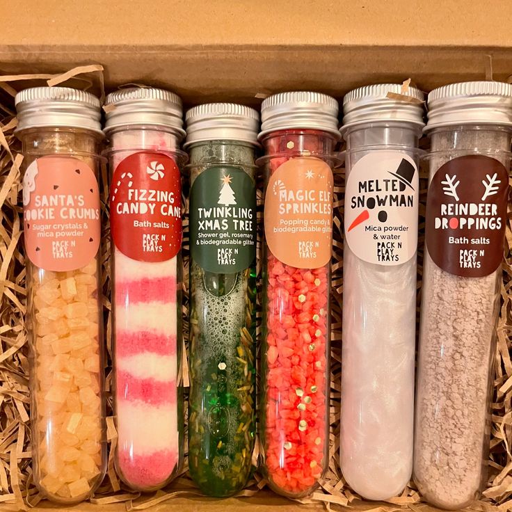 Festive bath salts and shower gel in test tubes with holiday-themed labels in a decorative box.