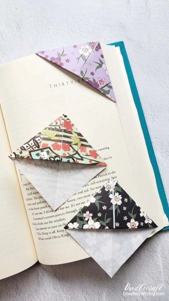 Floral corner bookmarks on open book pages, showcasing DIY origami style and colorful patterns.