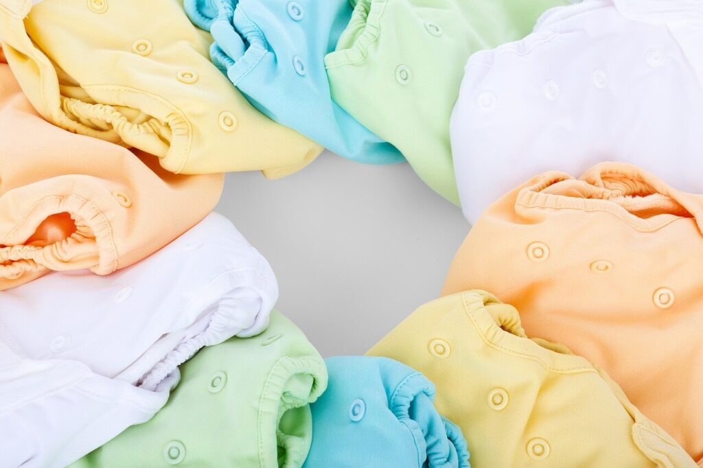 Colorful cloth diapers arranged in a circle showcasing various pastel shades for eco-friendly baby care.