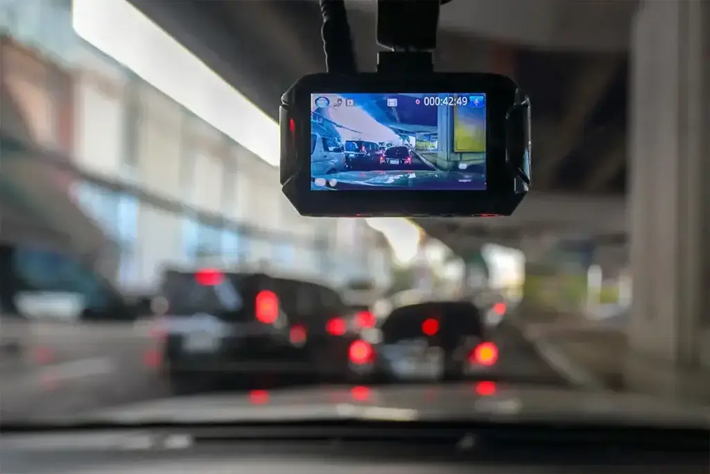 Dashcam view capturing heavy traffic under an overpass, displaying video timestamp and cars.