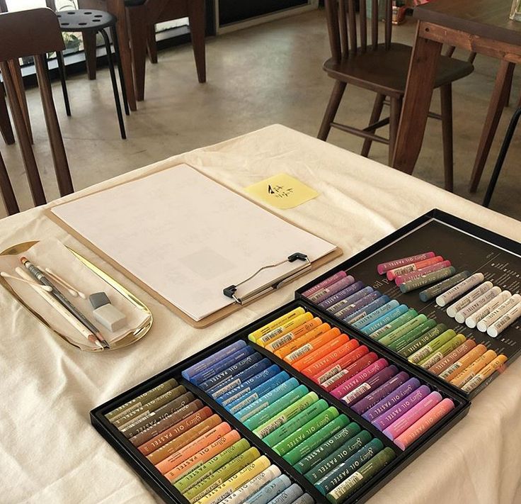 Art supplies on a table: clipboard, brushes, and colorful pastels ready for creative work.