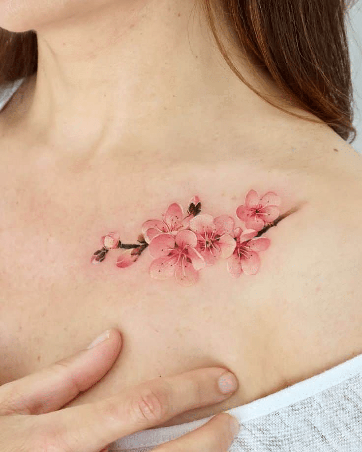 image Chest tattoo of cherry blossoms, pink flowers in delicate design on woman's skin, showcasing floral body art inspiration. | Sky Rye Design Chest tattoo of cherry blossoms, pink flowers in delicate design on woman's skin, showcasing floral body art inspiration.