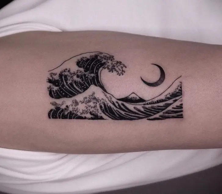 Minimalist wave tattoo with crescent moon on skin, inspired by Japanese art style.