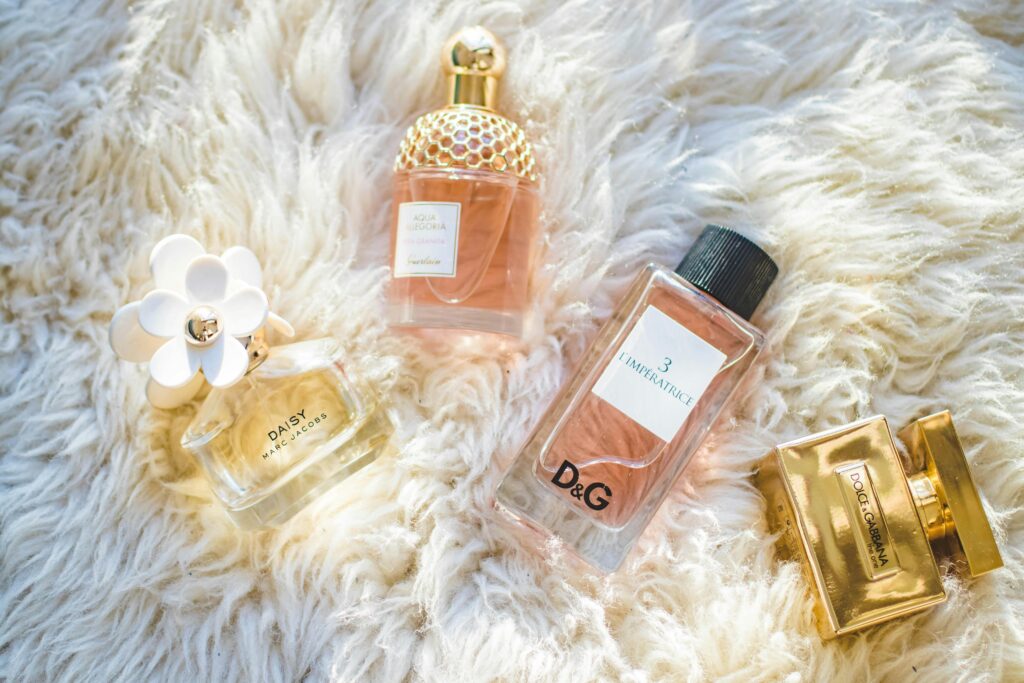 Perfume bottles displayed on fluffy white fabric, featuring various luxury fragrances for an elegant presentation.