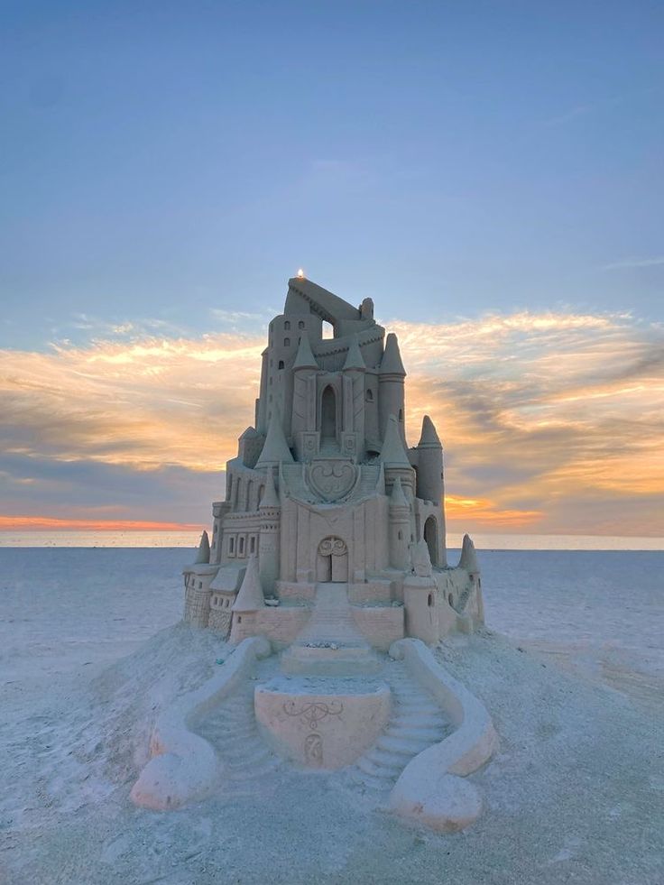 Intricate sandcastle on the beach at sunset, capturing creative design against a vibrant sky backdrop.