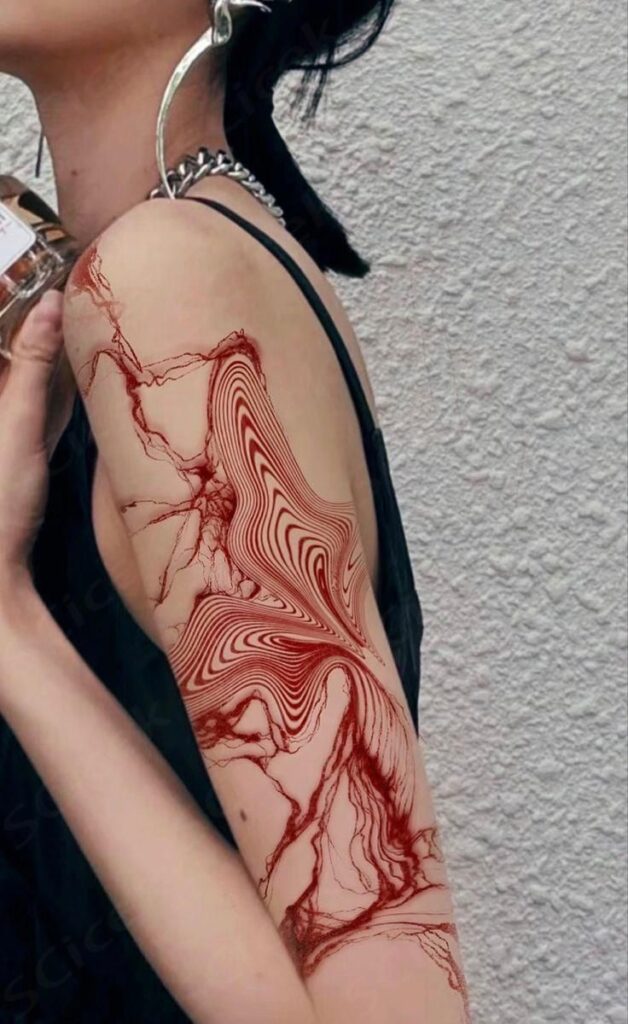 Abstract red tattoo sleeve design on woman's arm, featuring intricate swirling patterns for an edgy look.