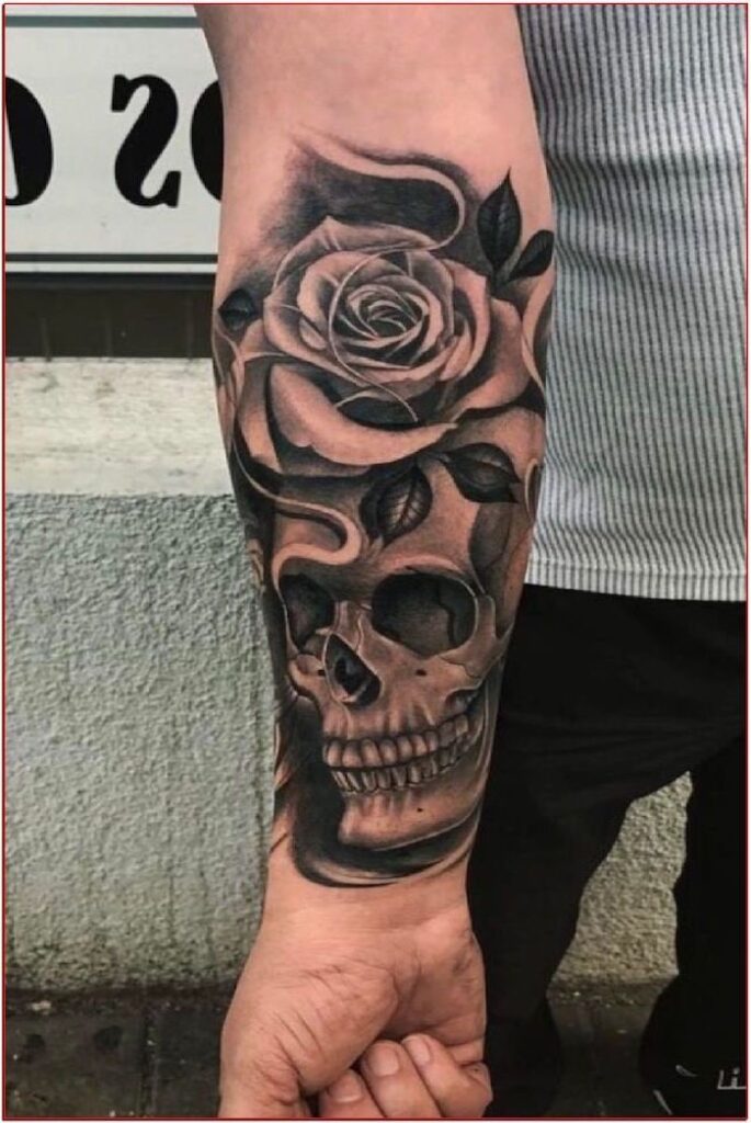 Forearm tattoo of a rose and skull in detailed black and gray ink design.