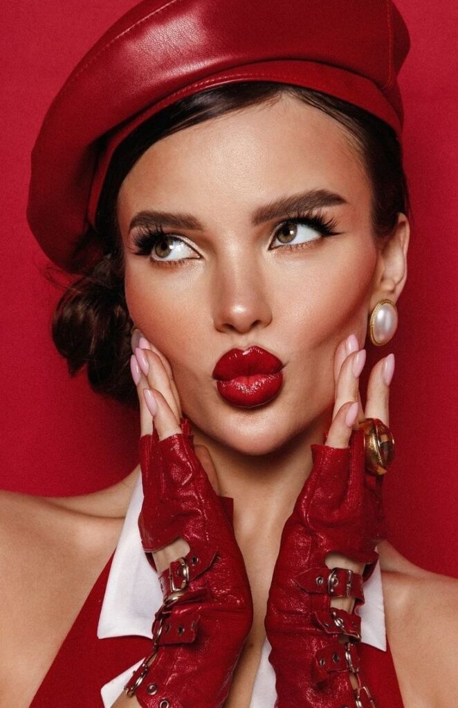 Портрет фотография 2025 красный Woman in red beret and gloves with bold red lips against red background, striking a playful pose. | Sky Rye Design Woman in red beret and gloves with bold red lips against red background, striking a playful pose.