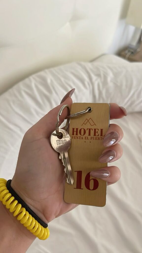 ℛℴℴ𝓂 16 Hand holding a hotel room key with number 16 tag, on a white bed background. | Sky Rye Design Hand holding a hotel room key with number 16 tag, on a white bed background.