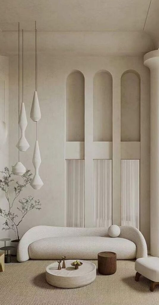 Stylish minimalist living room with white sofa, pendant lights, and wooden accents. Neutral tones create a serene atmosphere.