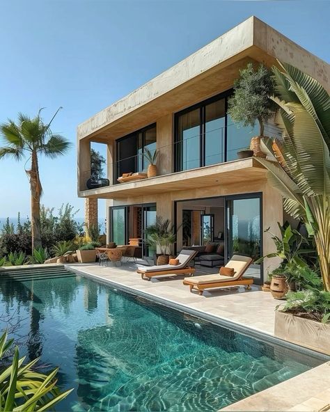 Modern luxury villa with pool, palm trees, and outdoor lounge area under a clear blue sky.