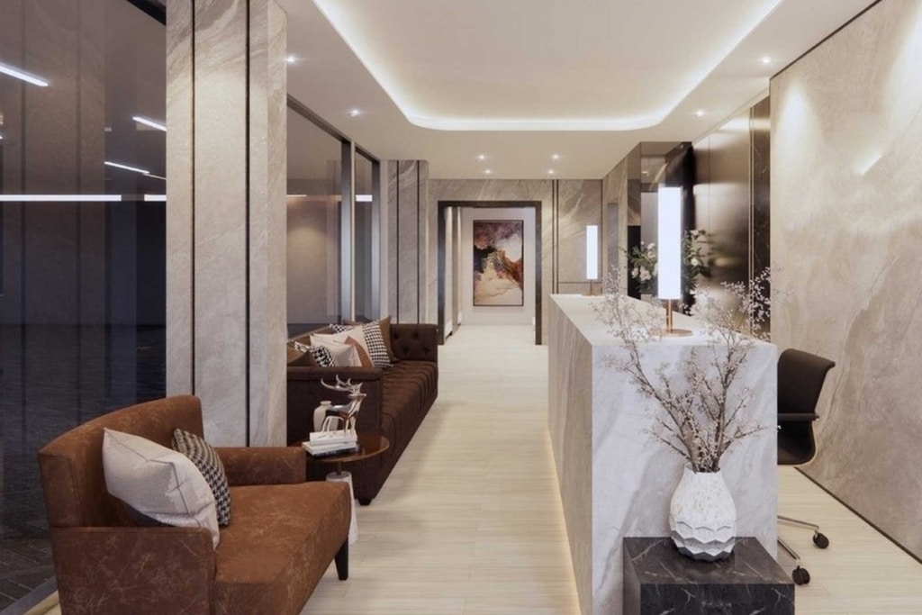 Modern office lobby with brown seating, marble desk, and elegant decor in a well-lit, sleek interior.