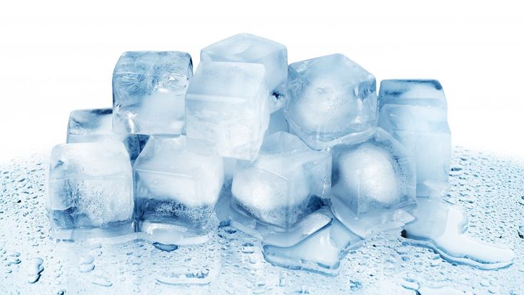 Pile of melting ice cubes with water droplets, ideal for cooling drinks or refreshing summer recipes.