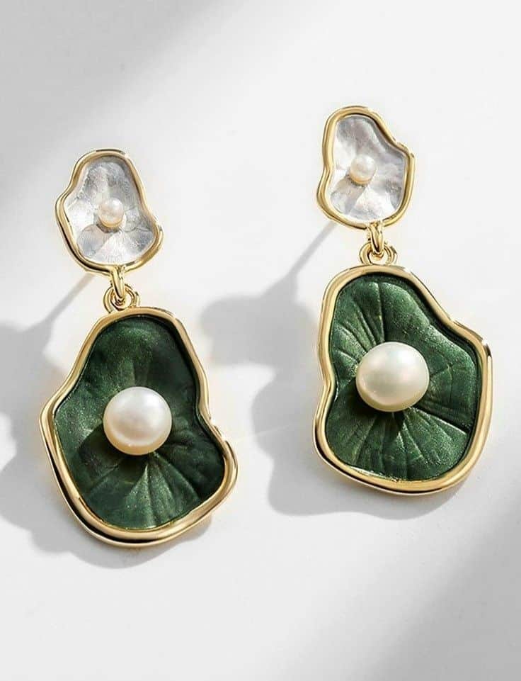 Gold drop earrings with green leaf design and central pearl detail, perfect for elegant fashion statements.