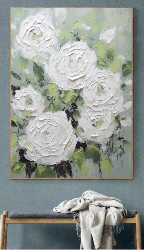 Textured painting of white roses on a green background above a bench with a draped blanket.