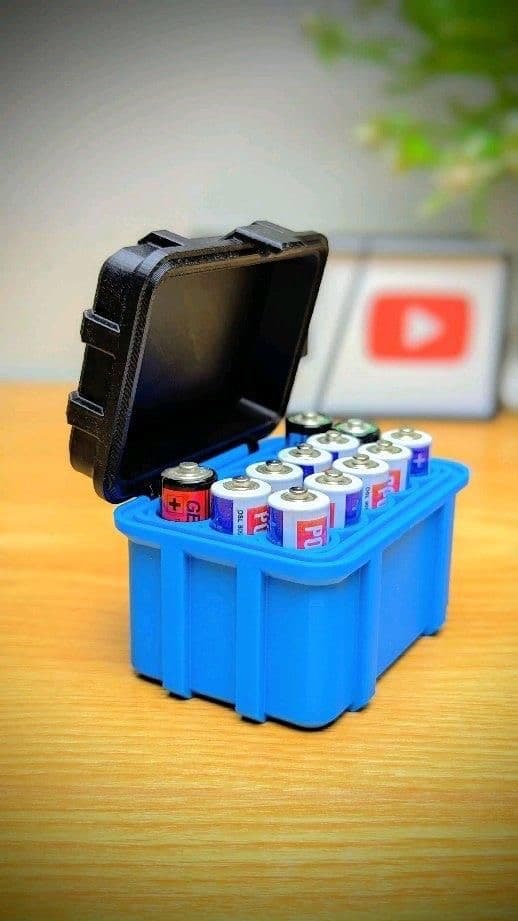 Blue battery case open, revealing multiple AA batteries inside, placed on a wooden table.