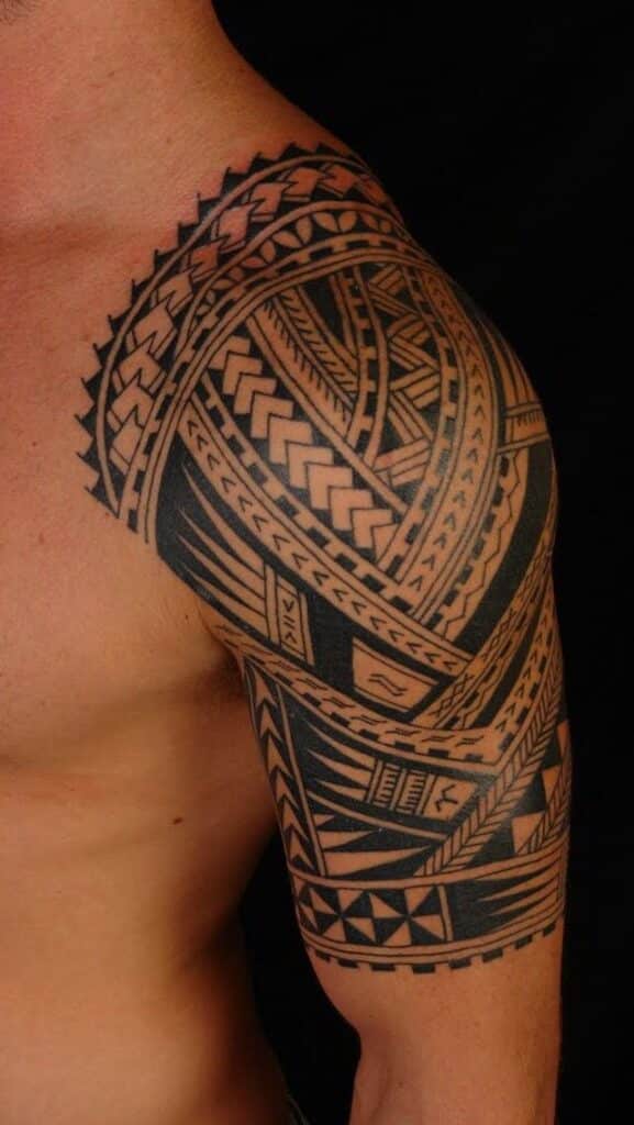 Intricate tribal shoulder tattoo design with geometric patterns on a bare upper arm.