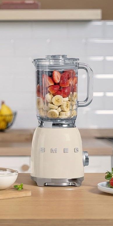 Vintage Smeg blender with bananas and strawberries in a modern kitchen setting.