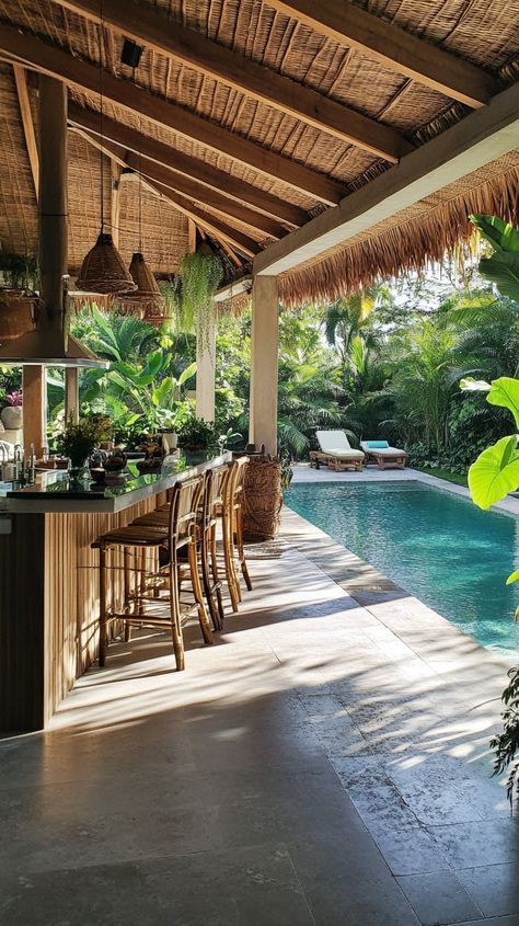 Tropical outdoor bar and seating area by a pool, surrounded by lush greenery and serene ambiance.