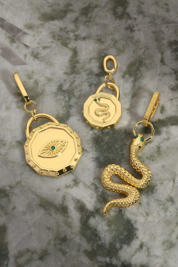 Elegant gold jewelry set with snake motif on marble background.