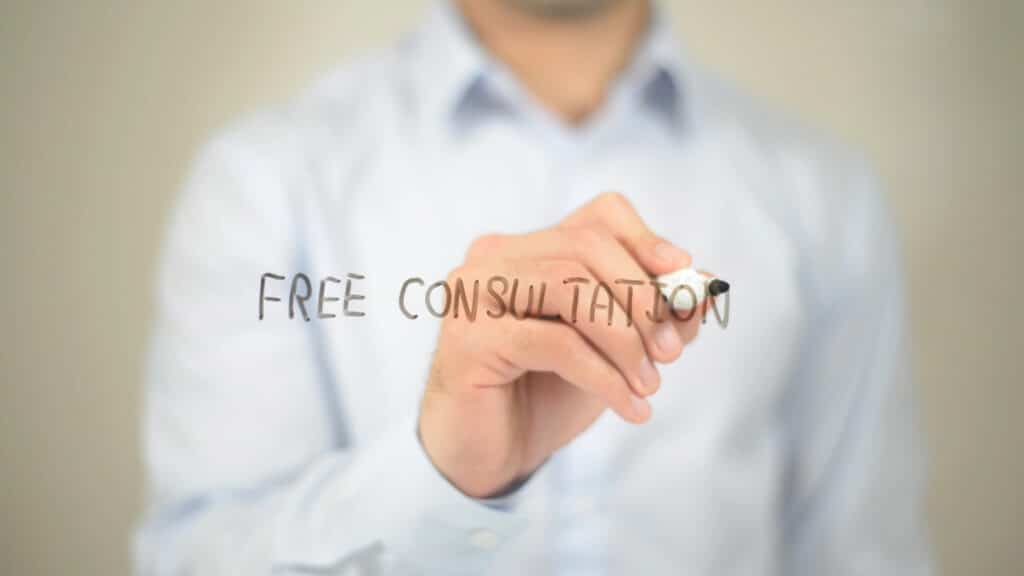 Person writing Free Consultation on transparent screen, offering professional advice service.