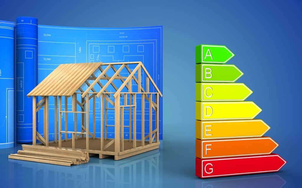 Wooden house frame with blueprints and energy efficiency ratings on a colorful scale from A to G.