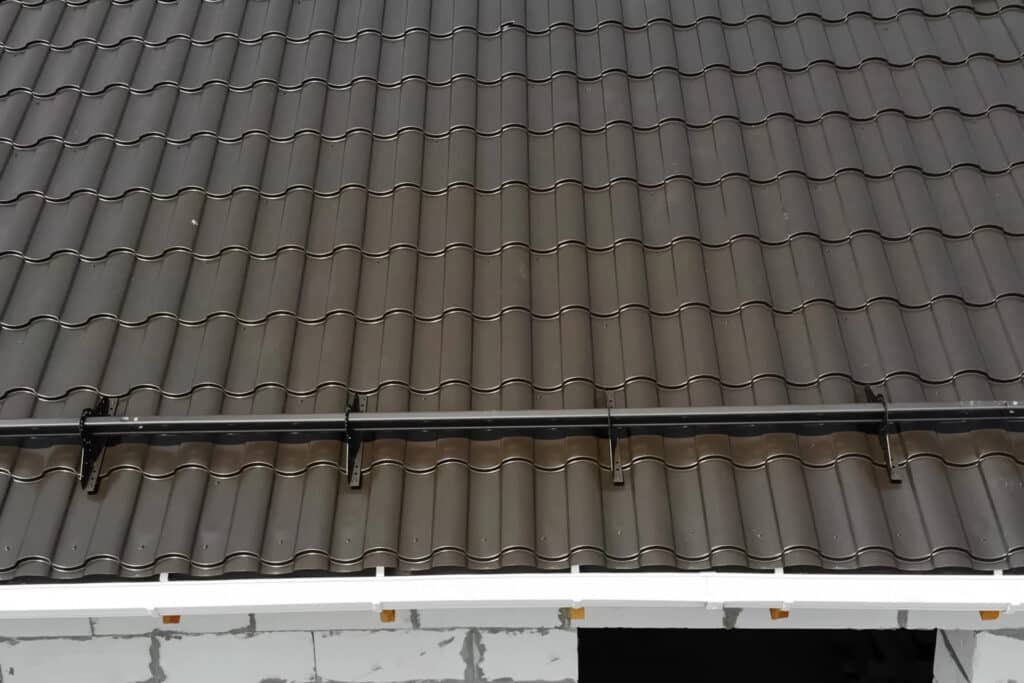 Close-up of a modern gray roof with tile pattern and gutter, suitable for residential buildings.