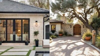 Luxurious stone house with modern design, glass doors, manicured lawn, driveway, and large tree.