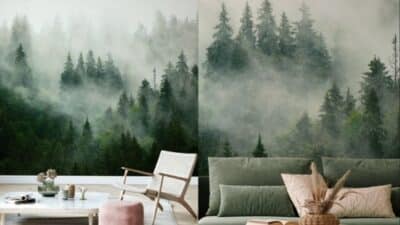 Living room with misty forest wall decor, green couch, pink cushions, and a airy, tranquil atmosphere.