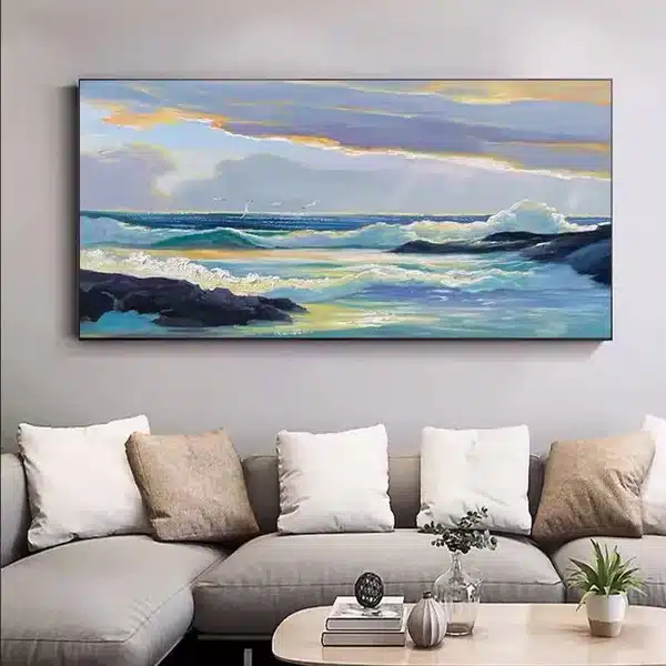 Wall art of ocean waves in a modern living room with a grey sofa and accent cushions.
