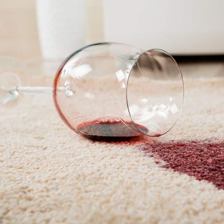 Spilled wine glass on carpet, red stain visible. Prevention and cleaning tips for carpet care.