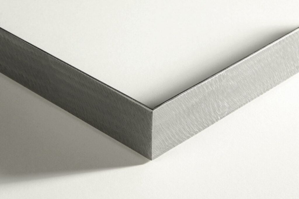 Close-up of a sleek silver picture frame corner on a white background.