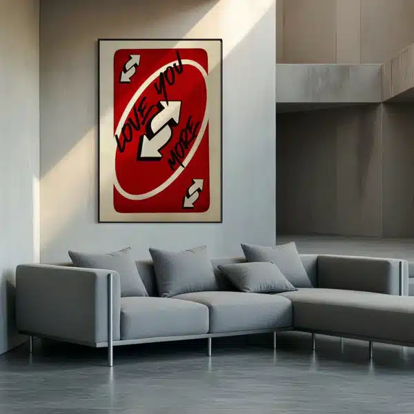 Modern living room with a gray sofa and a red Love You More art piece on the wall.