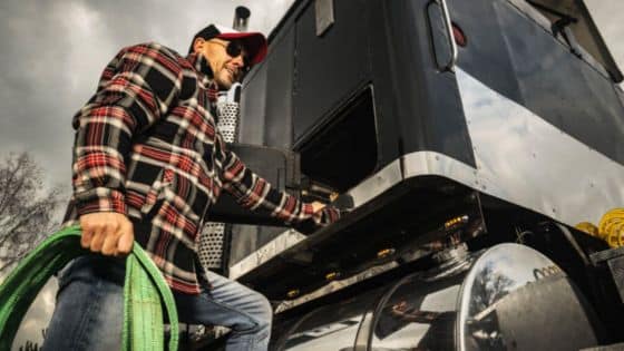 Reasons Are the Best Choice for Field Maintenance Man in plaid shirt with green rope climbing a black truck under cloudy skies. | Sky Rye Design Man in plaid shirt with green rope climbing a black truck under cloudy skies.