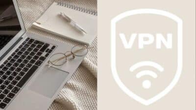 Open laptop with glasses and notebook on textured surface, next to a VPN shield logo, implying online security.