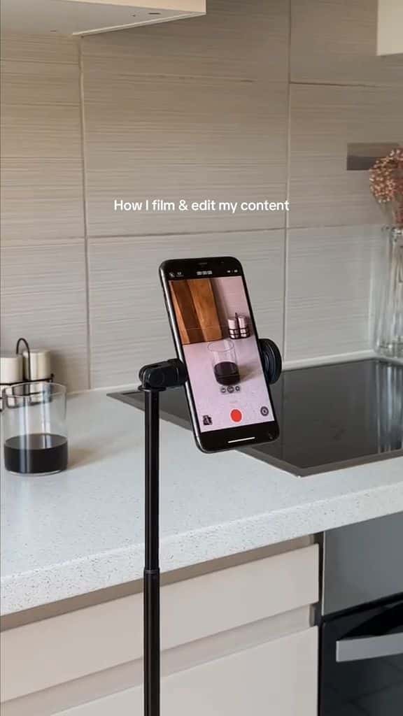 Smartphone on a tripod filming a kitchen setup for content creation.